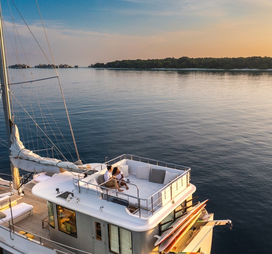 Ein Paar entspannt auf einem Schiff und beobachtet den Sonnenuntergang.