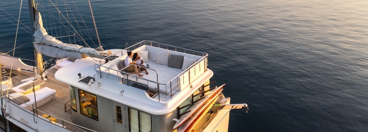 Ein Paar entspannt auf einem Schiff und beobachtet den Sonnenuntergang.