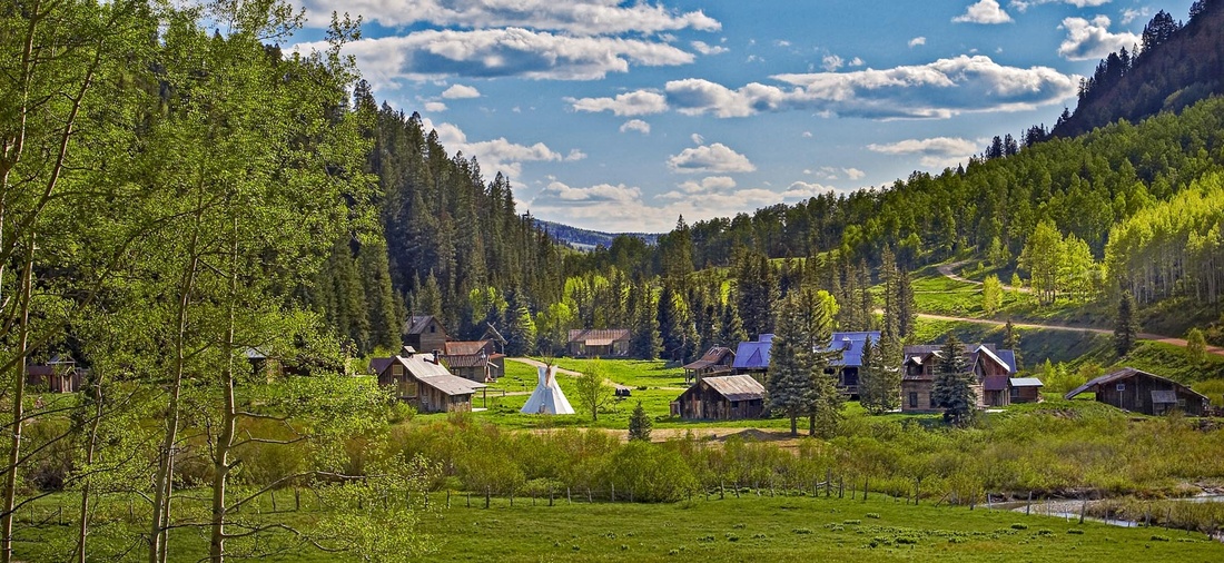 Kleine Siedlung mit Holzhütten in grüner Natur