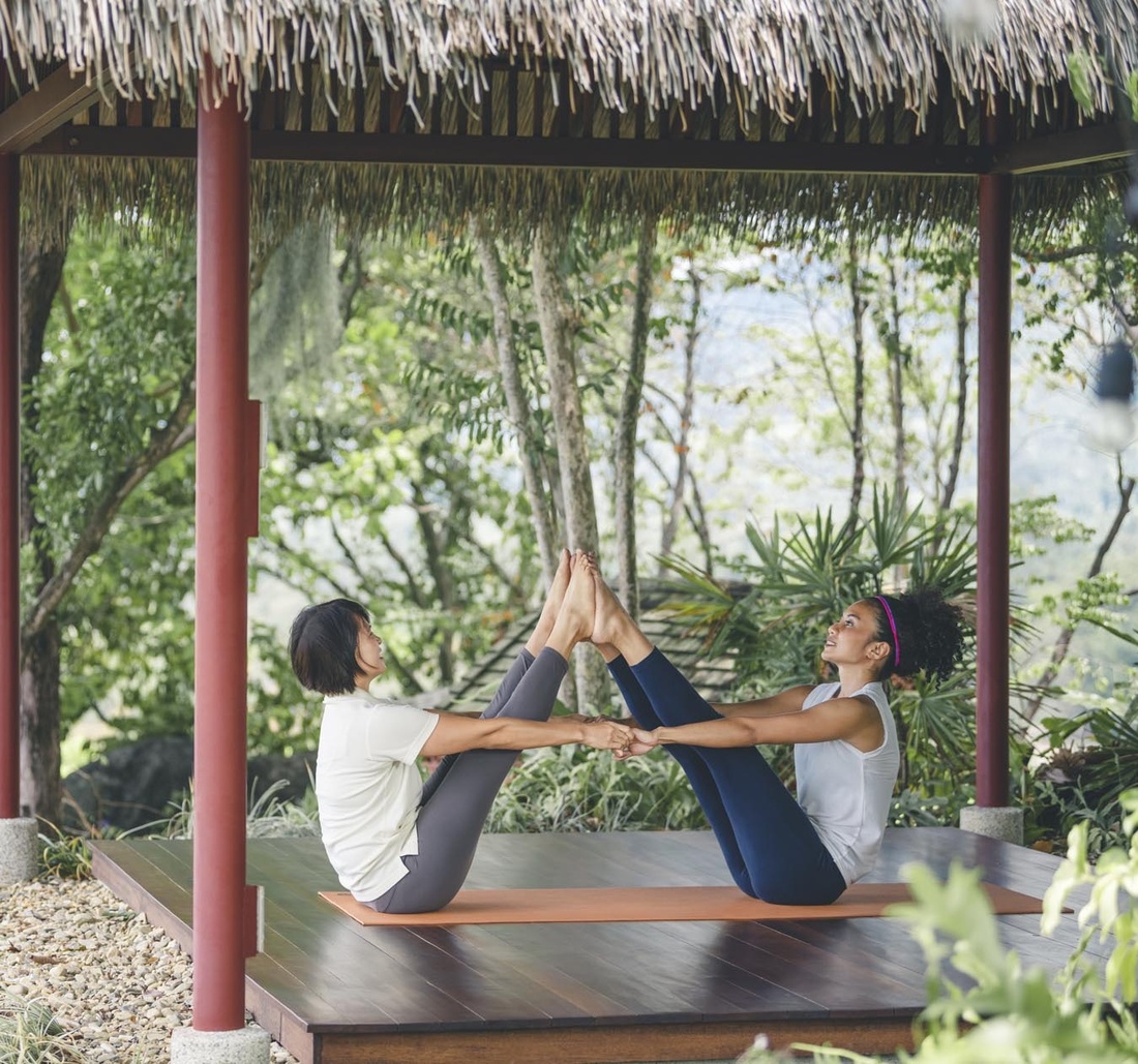 Zwei Frauen machen zusammen Yoga.