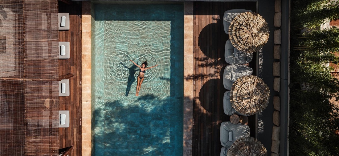 Eine Frau in einem schwarzen Bikini schwimmt im Pool.