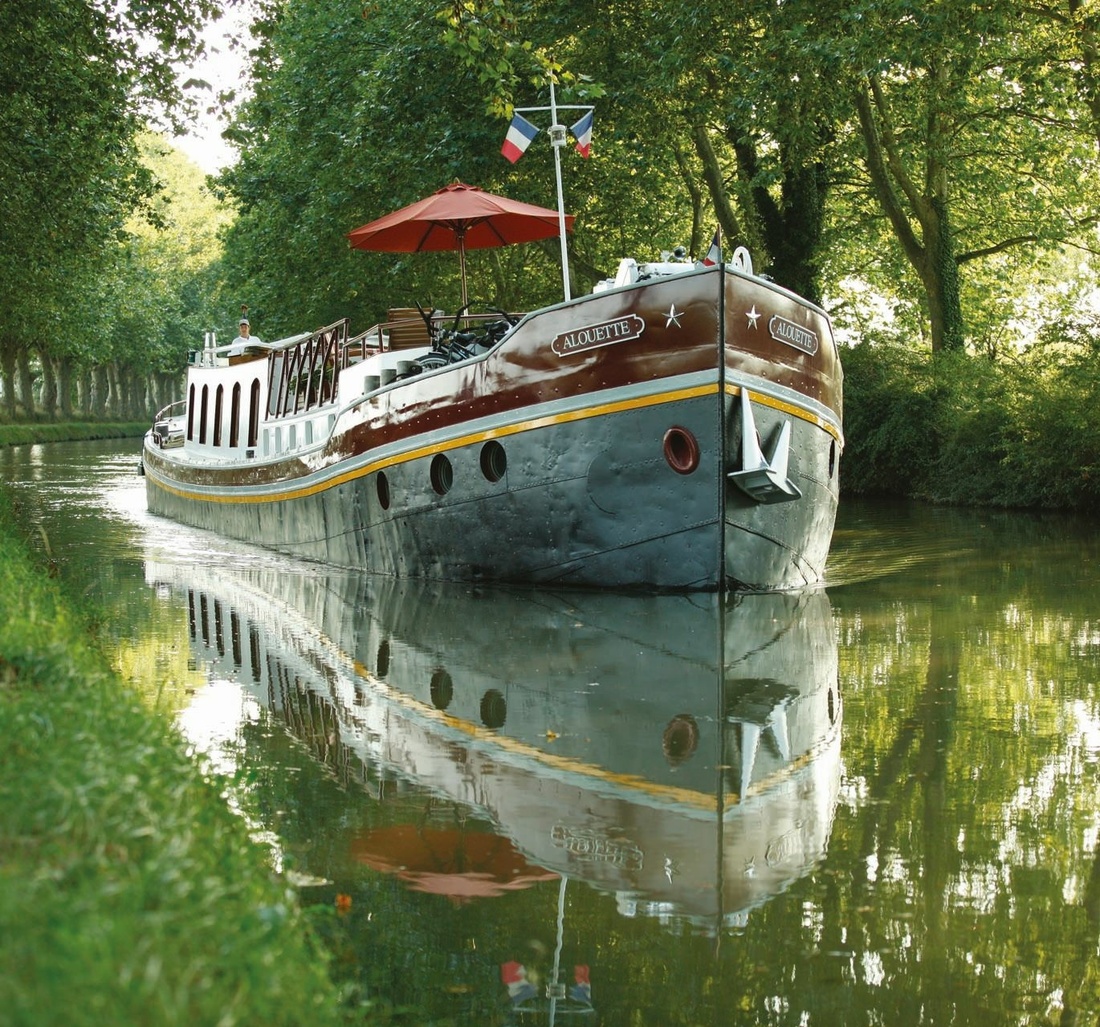 Ein Aluminium-Boot fährt auf einem Fluss.