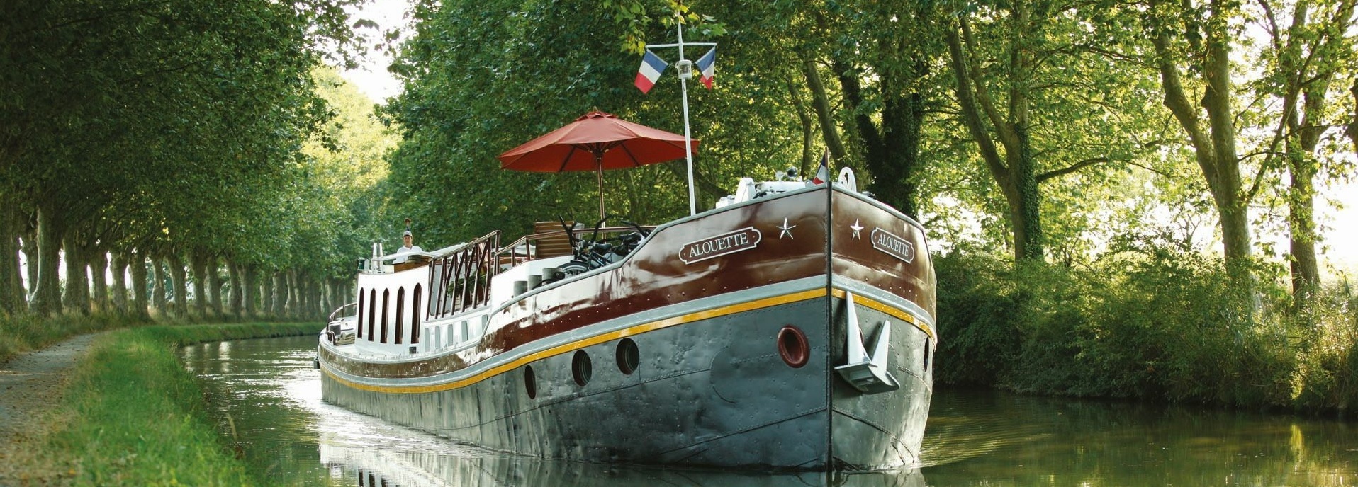 Ein Aluminium-Boot fährt auf einem Fluss.
