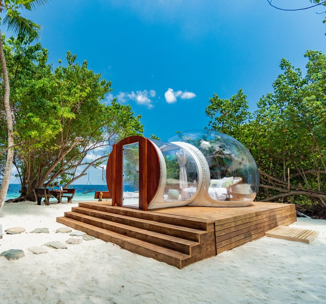 Ein kleines Blasenhaus mit Bett auf einer Insel.