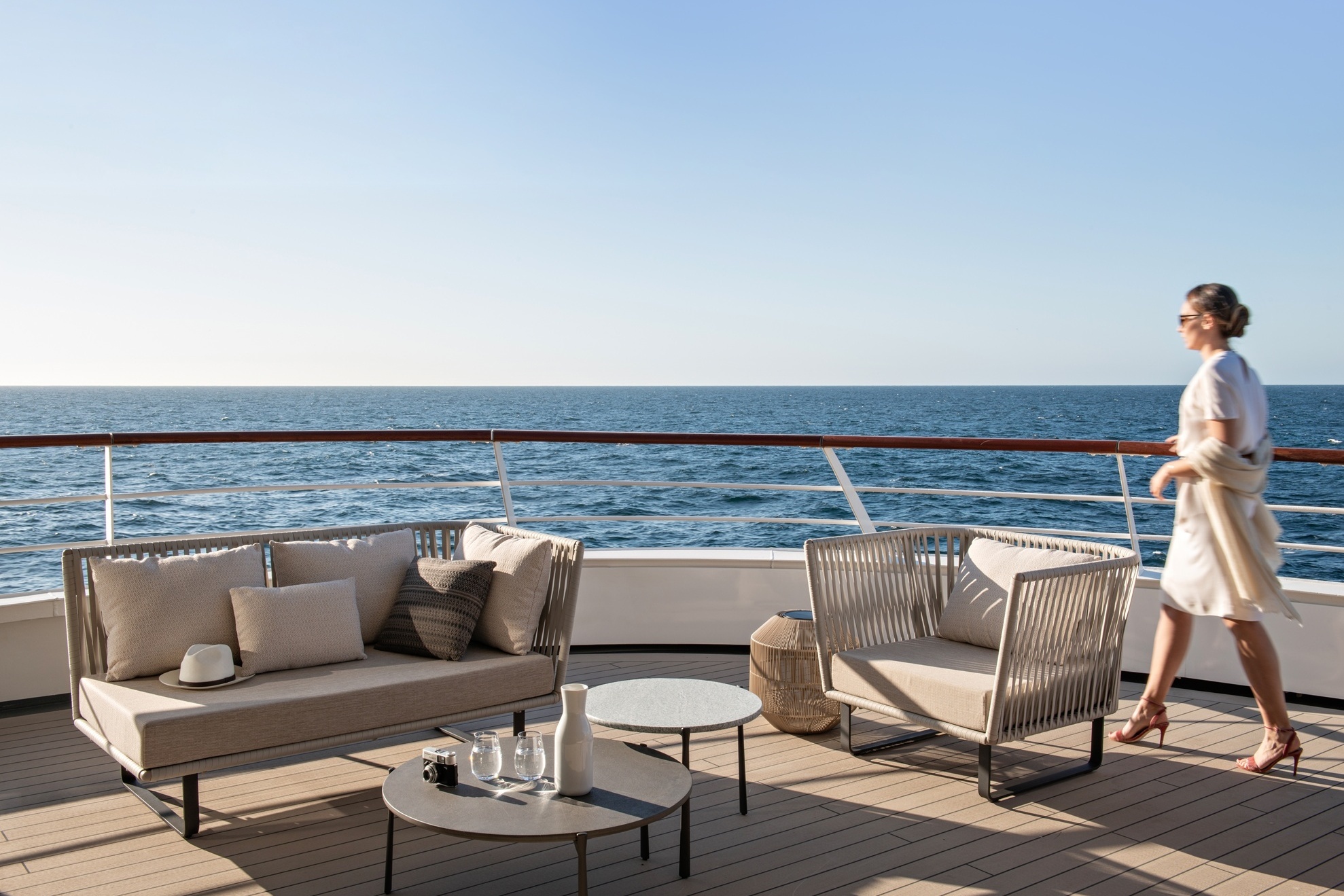 Frau läuft zum Lounge Bereich an Deck der Ponant Yacht