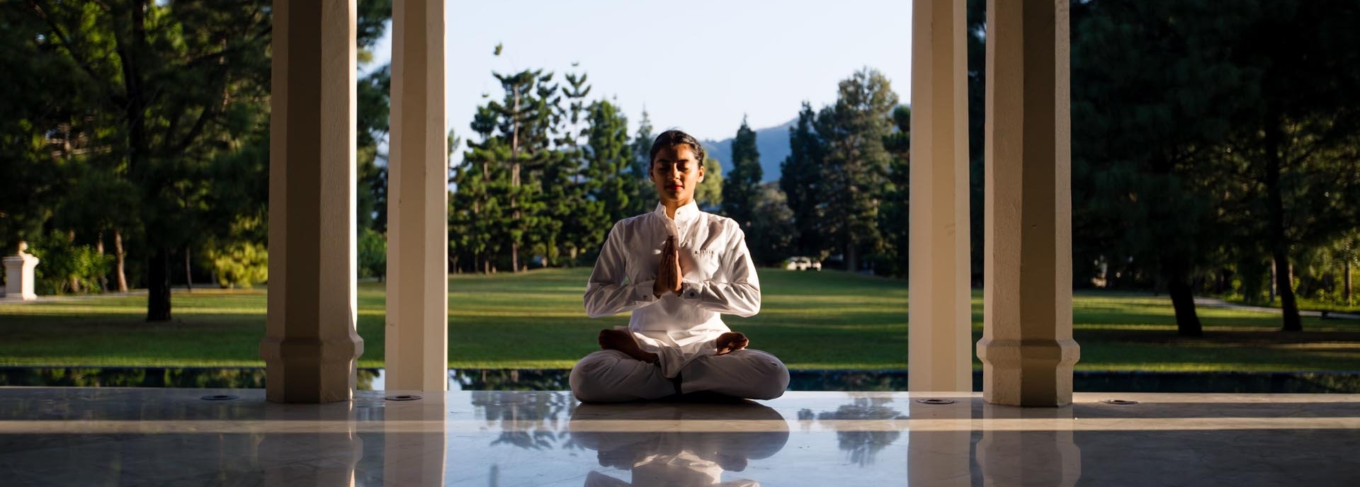 Eine Frau sitzt im Schneidersitz auf dem Boden.