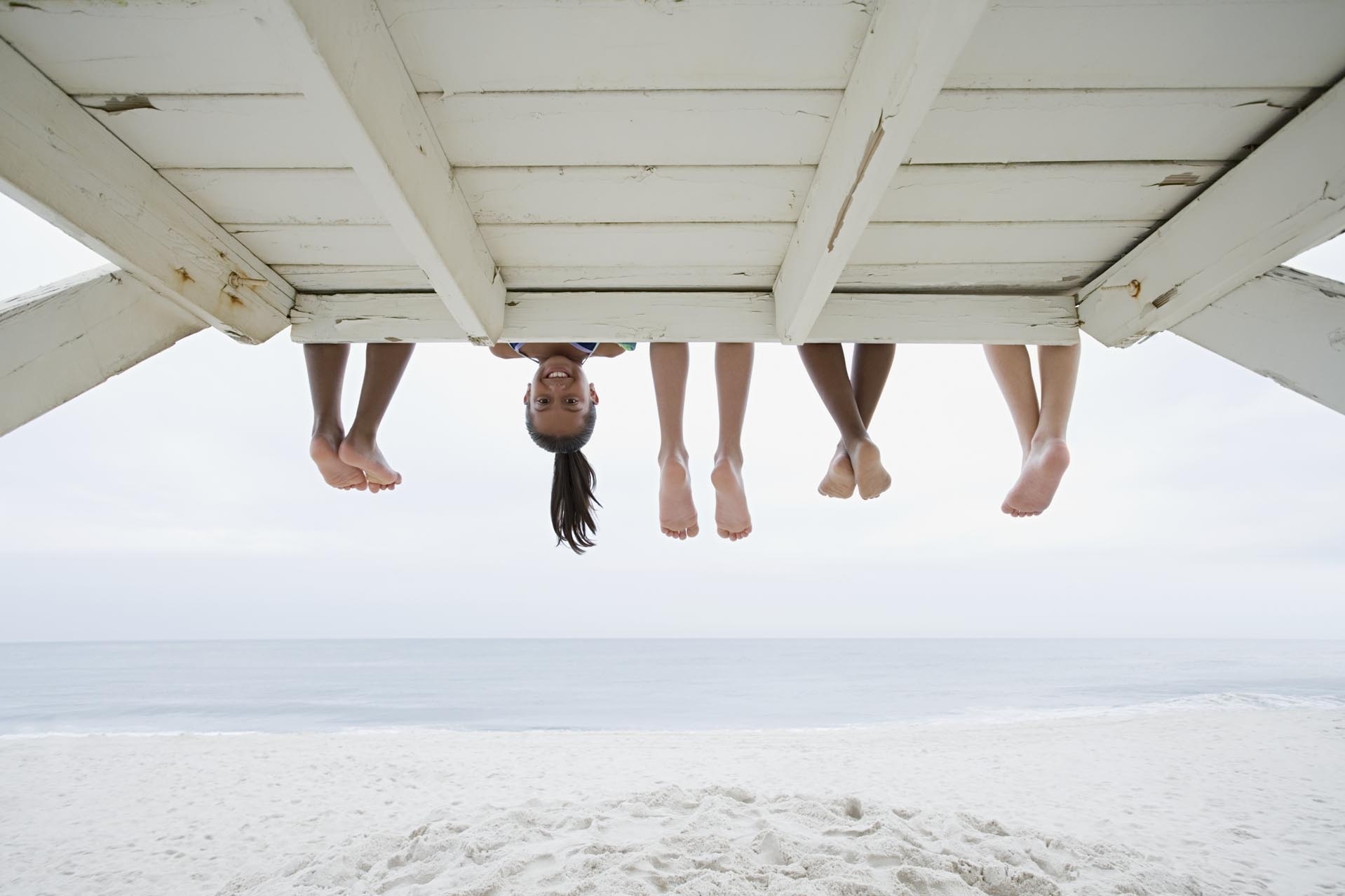 Kinder sitzen auf einem Aussichtsposten am Strand.