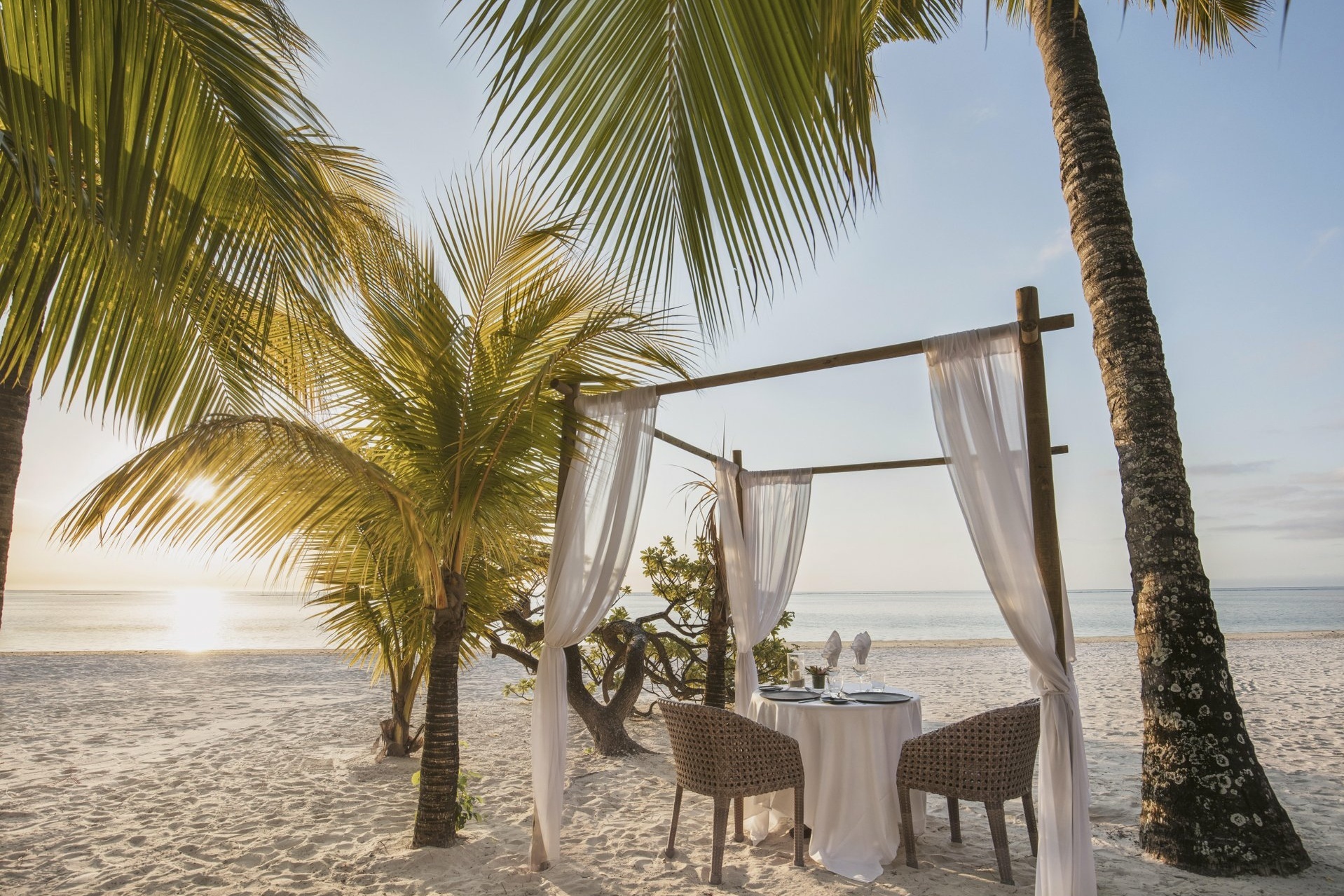 gedeckter Tisch am Strand unter Palmen