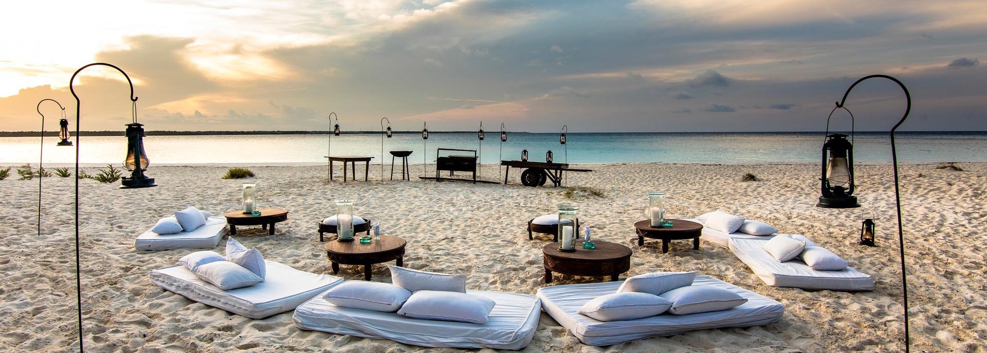 Kleine Tische und mehrere Sitzmöglichkeiten am Strand.