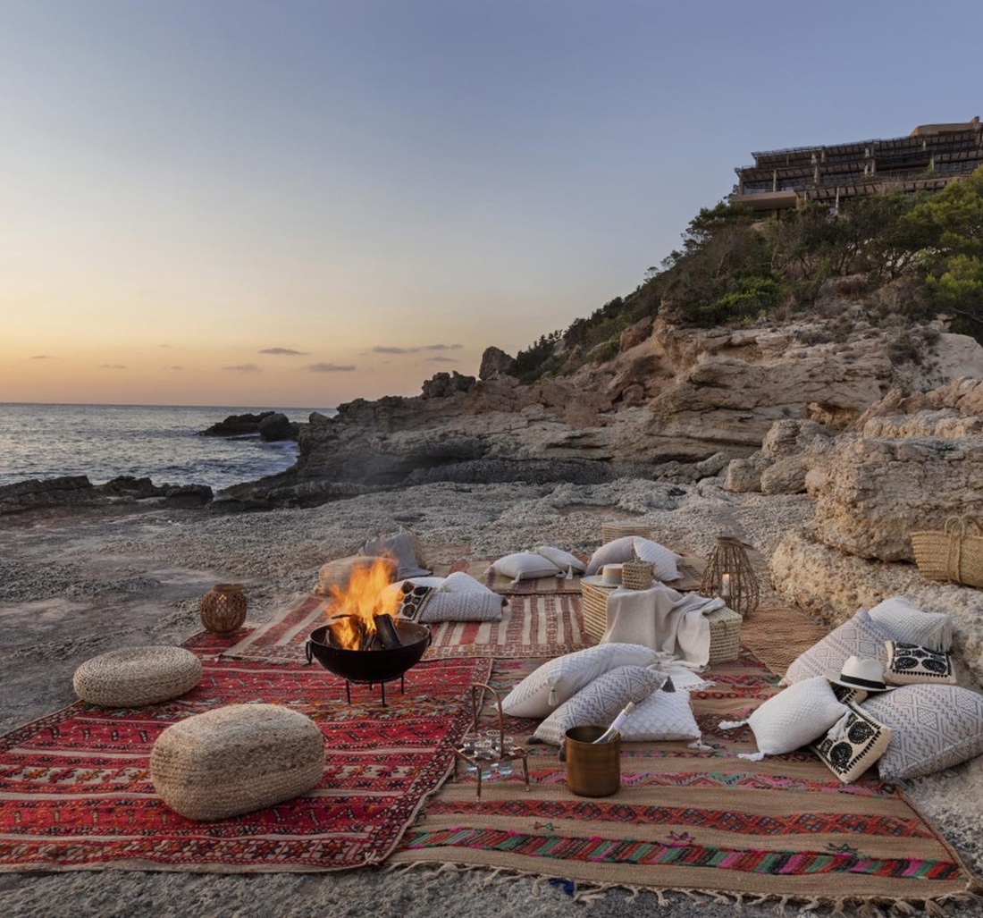 Decken und ein Lagerfeuer am Strand. 