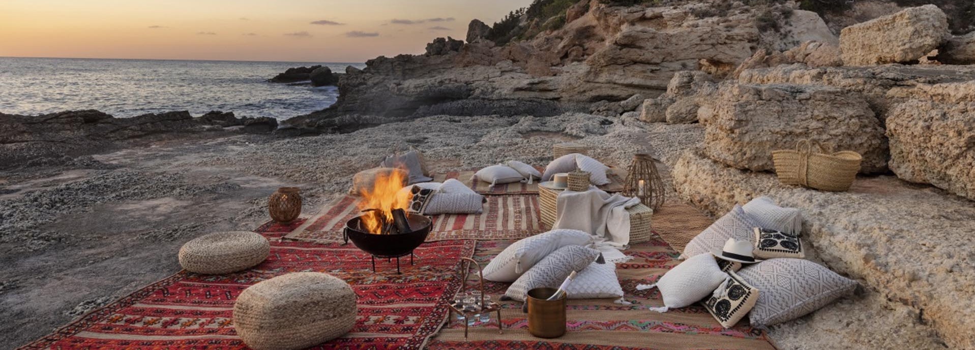 Decken und ein Lagerfeuer am Strand. 