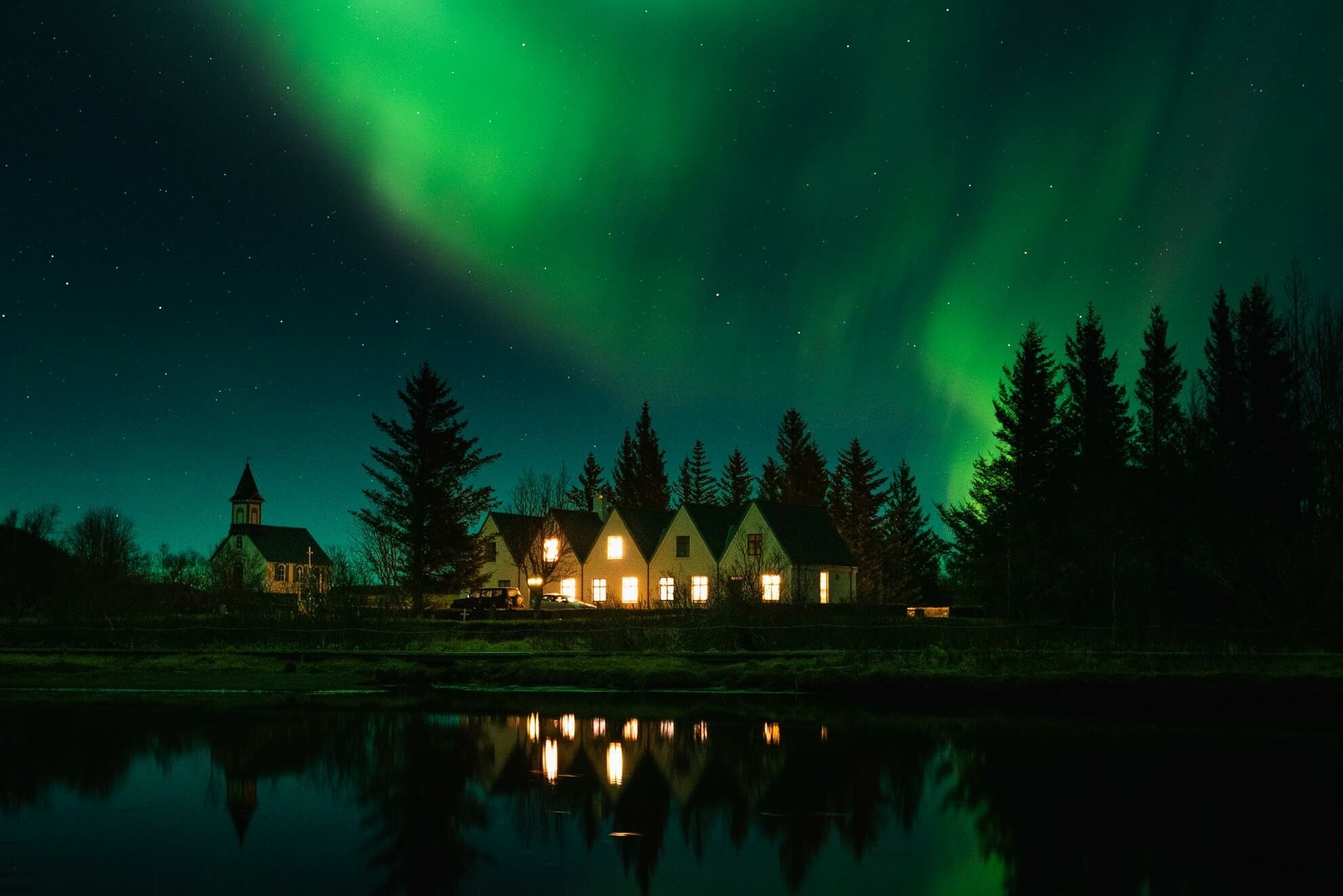 Nordlichter über Häuser in Island.