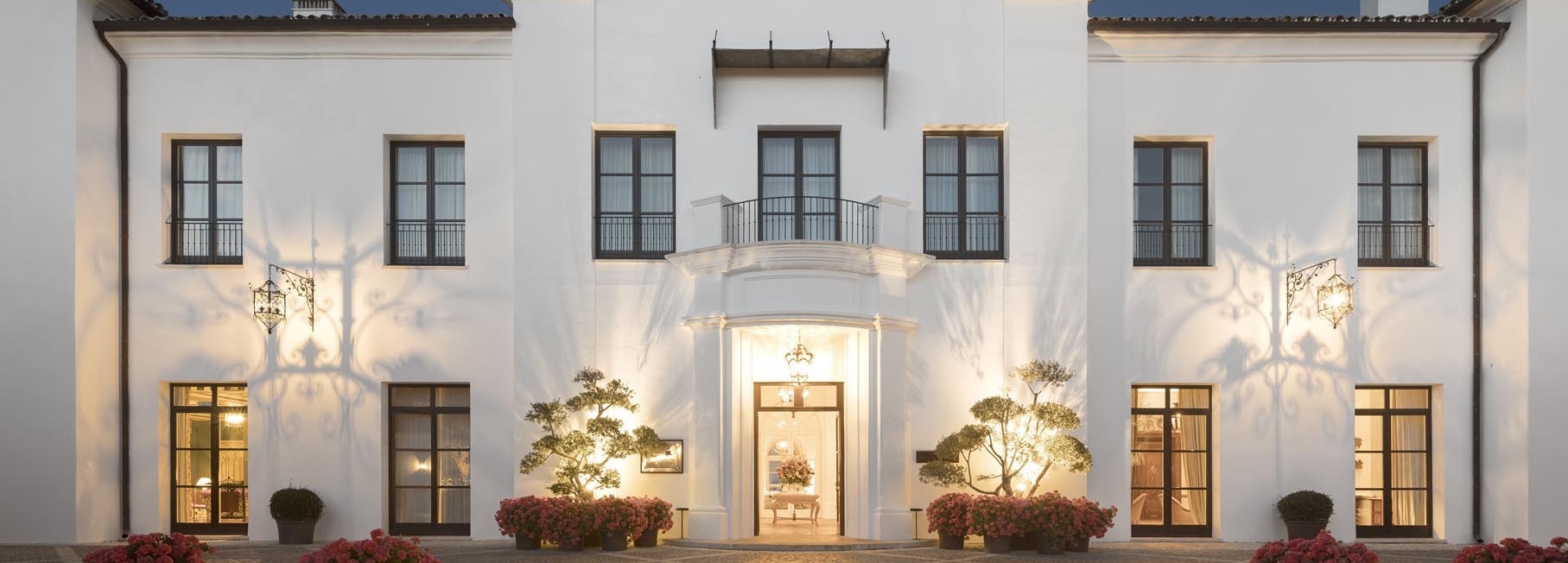 Blick von außen auf ein weißes Hotel.