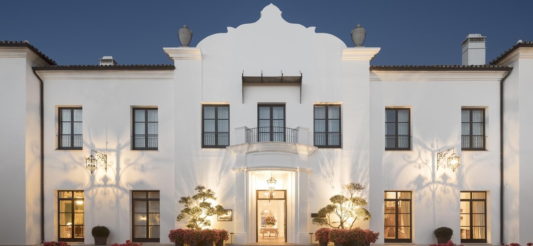 Blick von außen auf ein weißes Hotel.