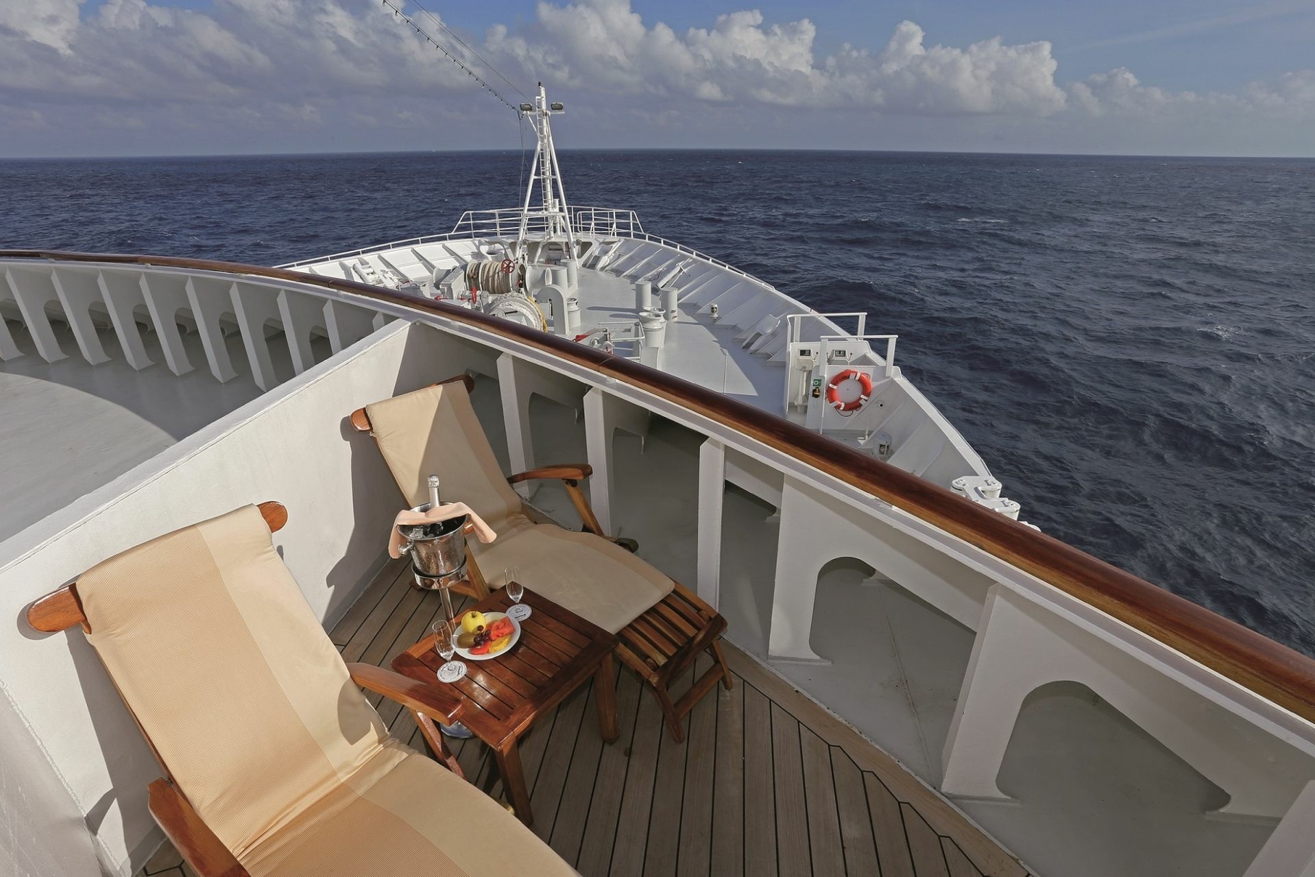 Zwei Liegestühle auf dem Deck eines Schiffes.