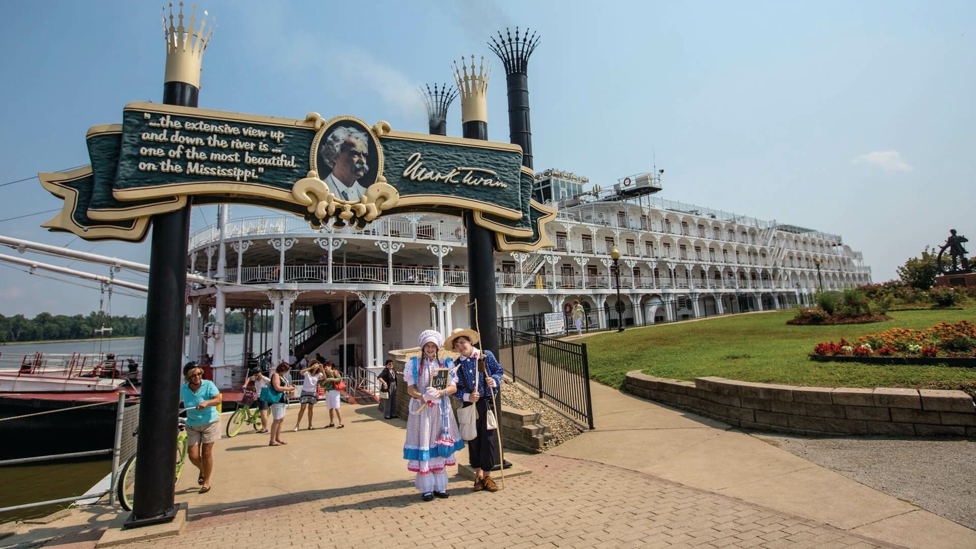 Zwei verkleidete Kinder vor einem großen Mississippi Kreuzfahrtschiff.