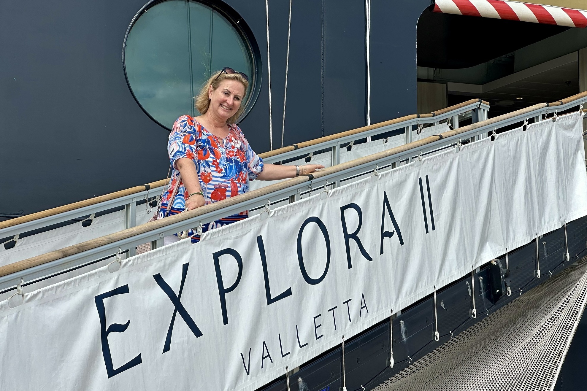 Eine Frau steht vor einem Kreuzfahrtschiff.