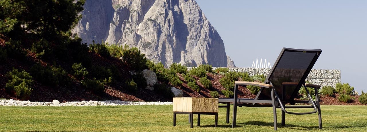 Ein Stuhl steht auf einer Wiese vor einem Pool.