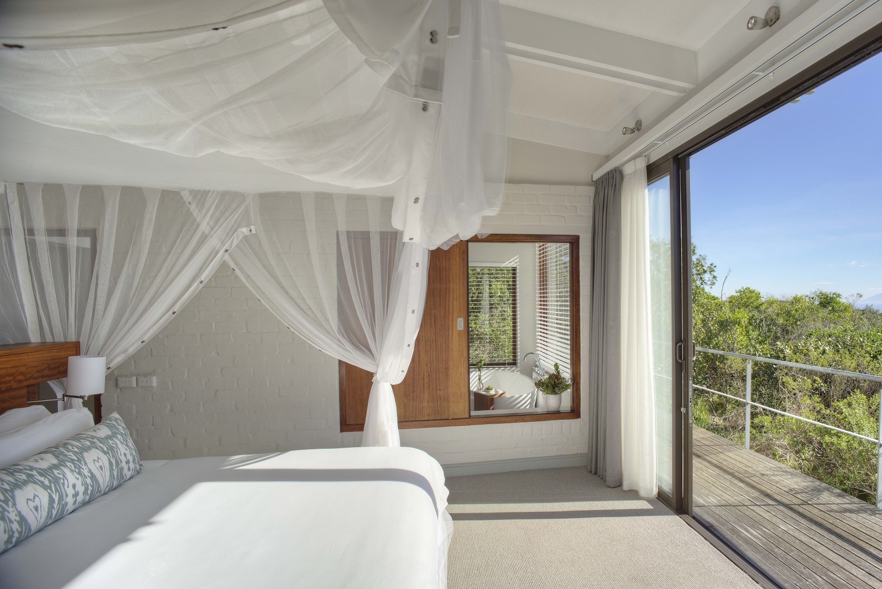 Eine modernes Schlafzimmer mit Blick in die Natur.