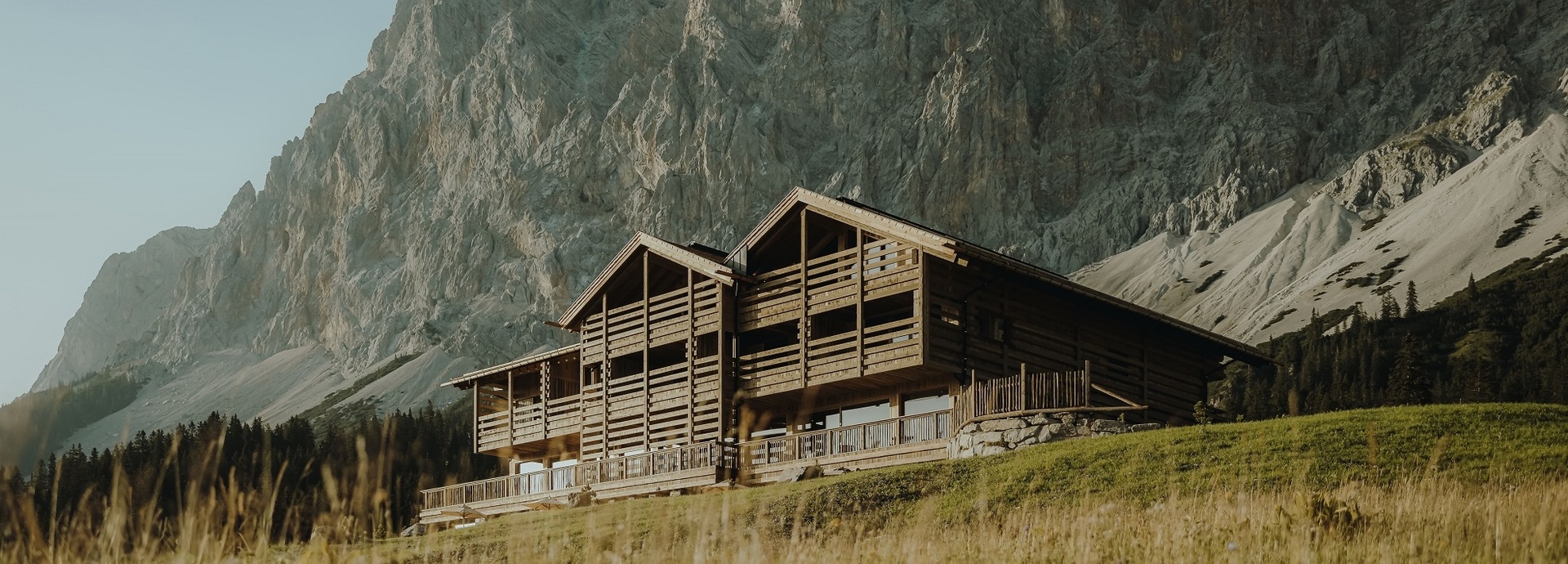 Blick auf ein Hotel vor einer Bergkulisse.