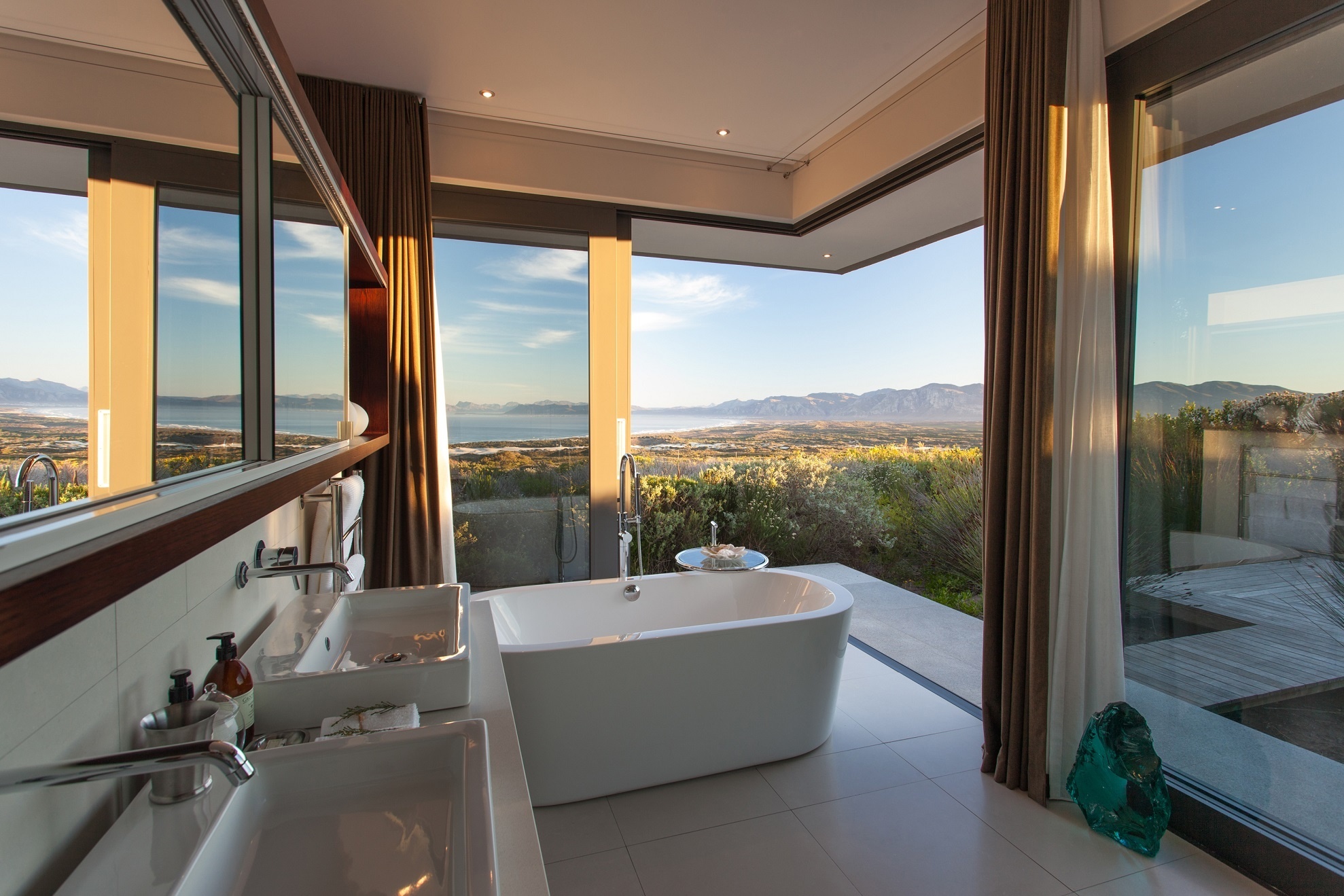 Eine Badewanne in einem Badezimmer mit großen Fenstern.