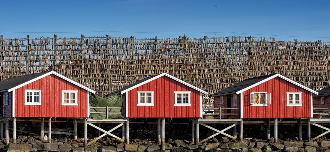 Drei kleine, rote Hütten in Norwegen.