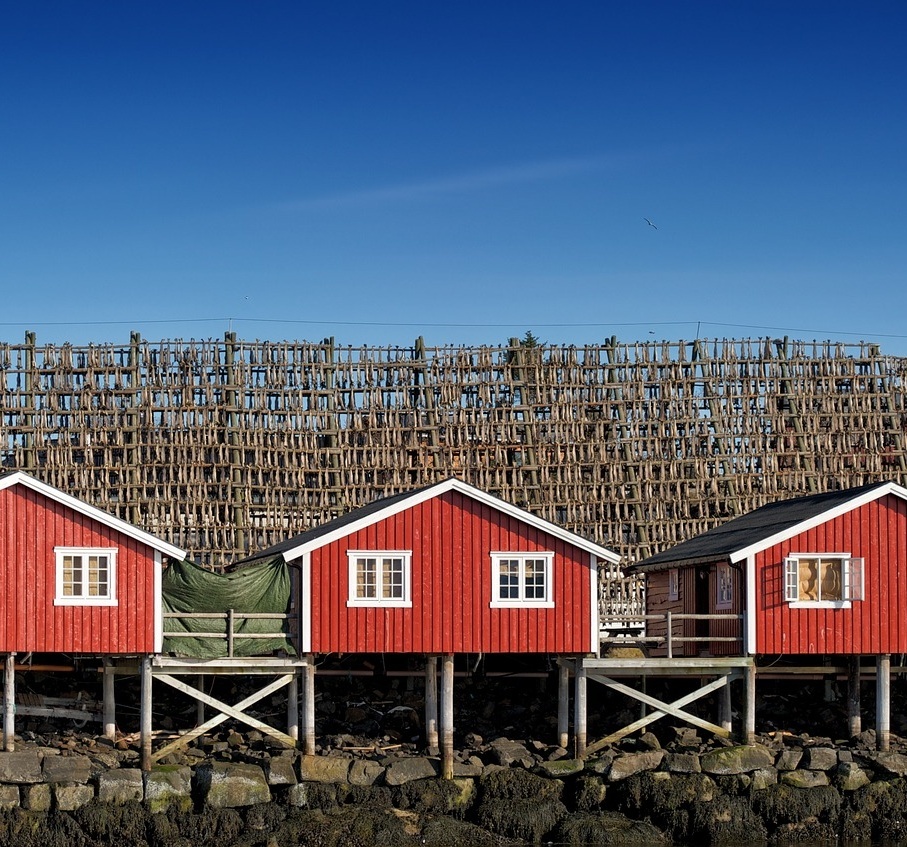 Drei kleine, rote Hütten in Norwegen.