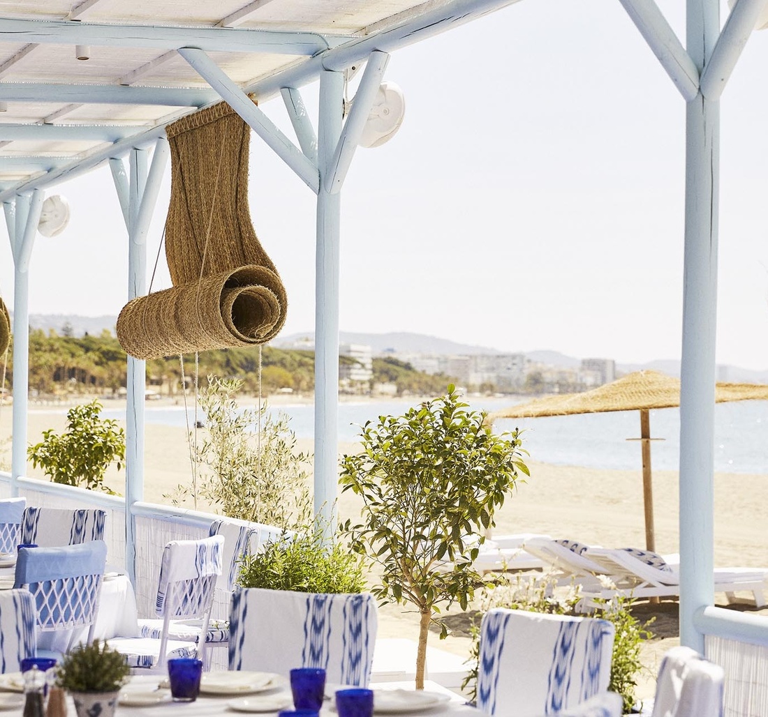 Terrasse mit gedeckten Tischen direkt am Strand.