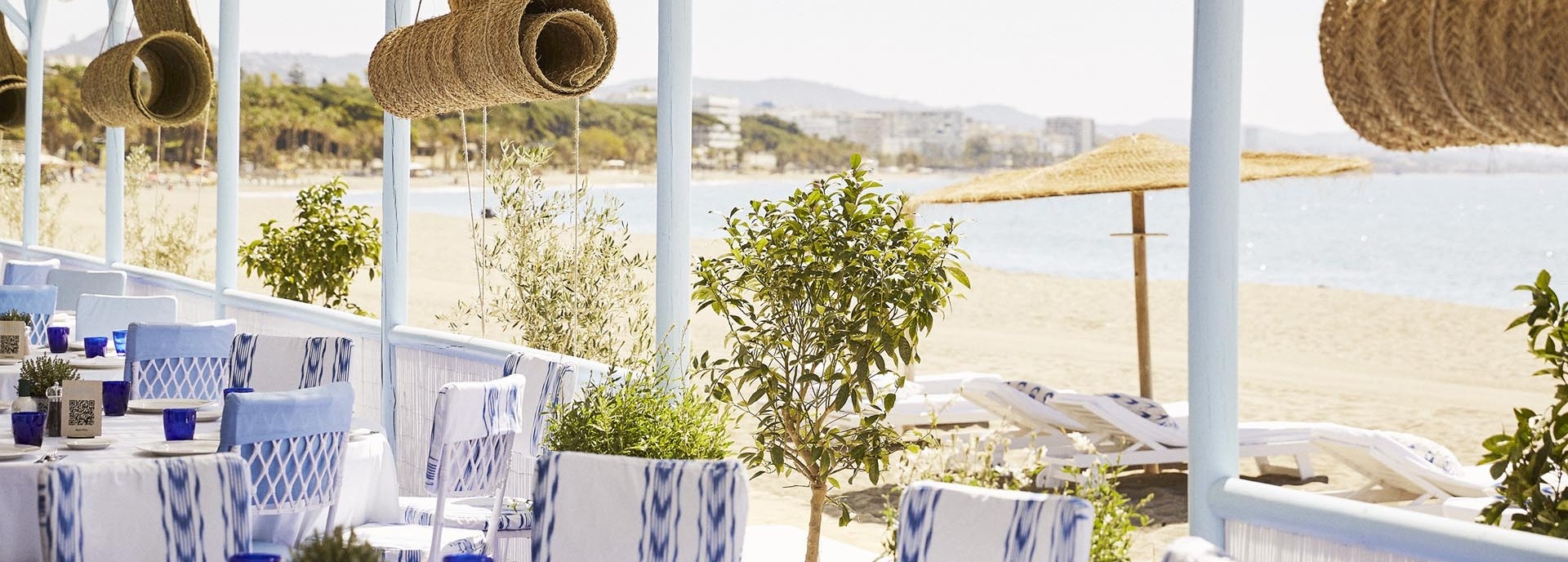 Terrasse mit gedeckten Tischen direkt am Strand.