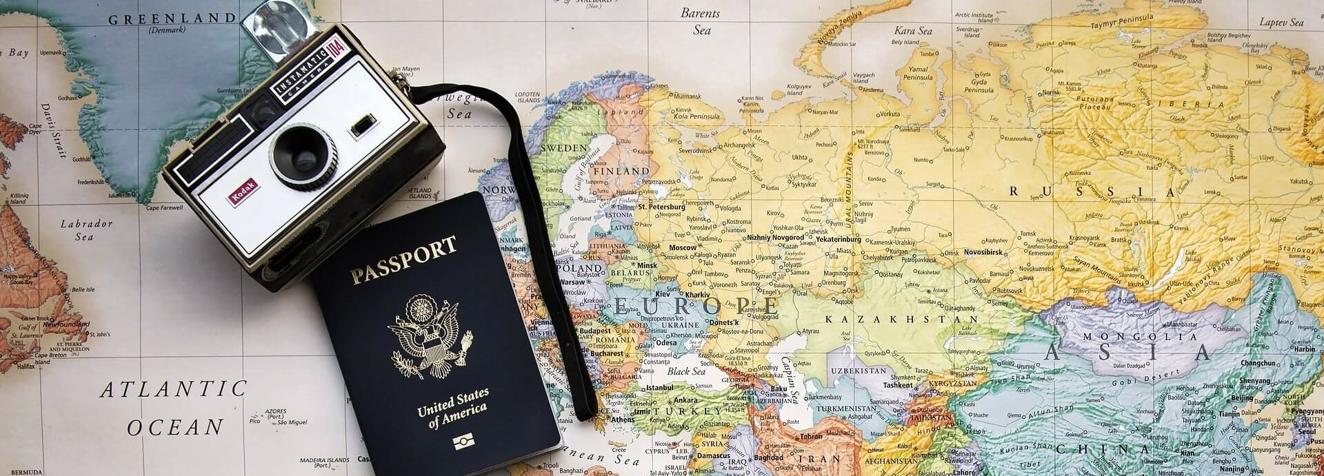 Landkarte auf der ein Pass und eine Kamera liegt