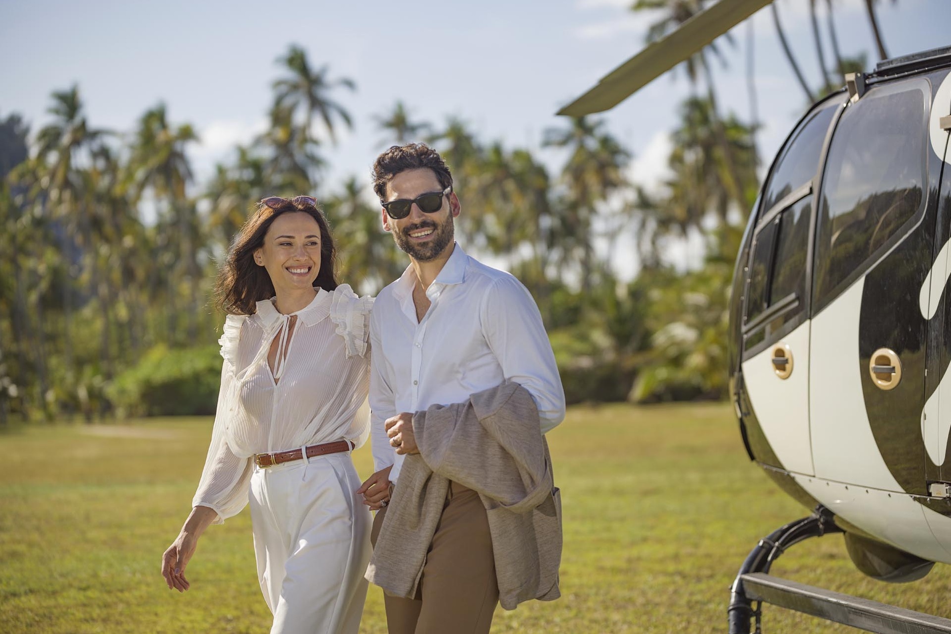 Ein Mann und eine Frau neben einem Helikopter.