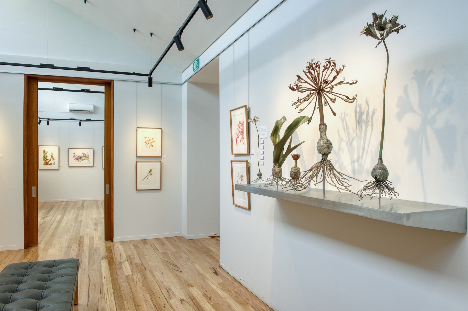 Eine Blumen Ausstellung mit Blumenbildern und Statuen.