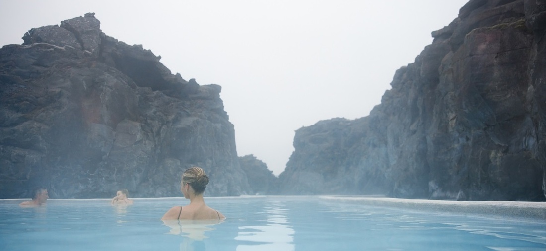 Eine Frau schwimmt in einer blauen Lagune.
