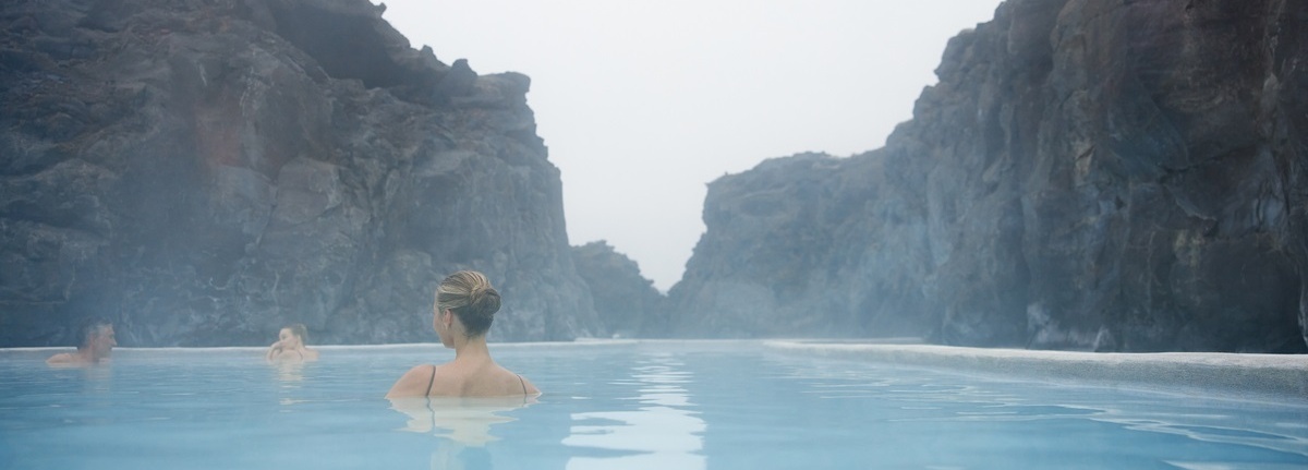 Eine Frau schwimmt in einer blauen Lagune.