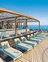 Ein Pool und Sonnenliegen am Deck eines Schiffes.