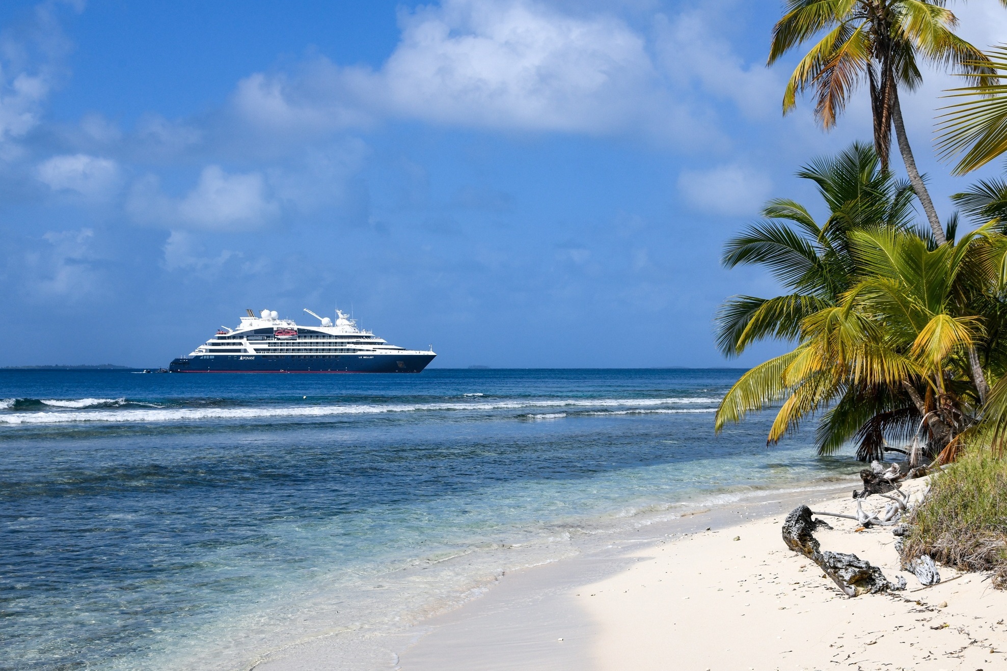 Ponant Yacht vom Strand mit Palmen aus fotografiert