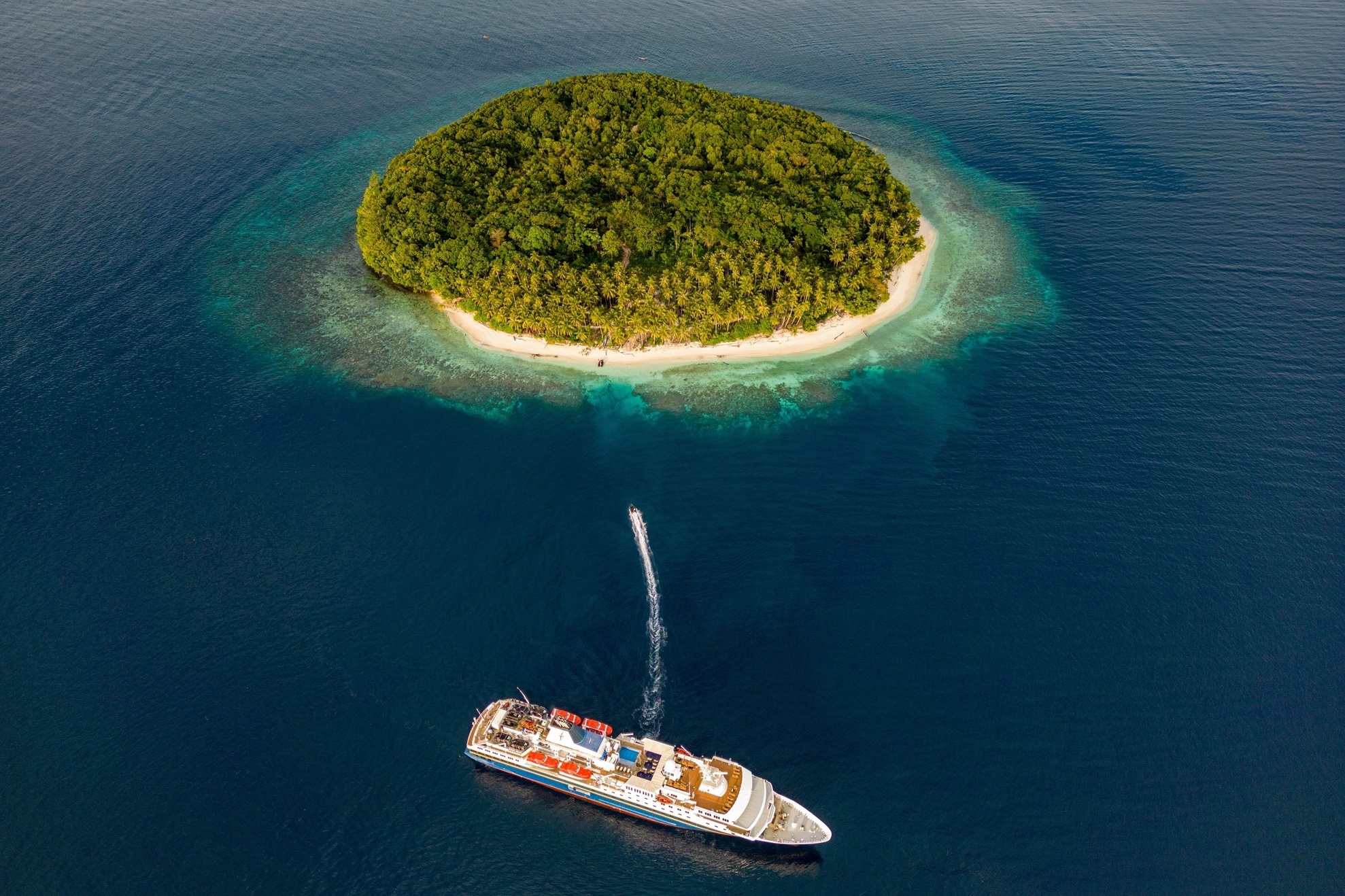 Adventurer von Heritage Expeditions vor einer runden Insel