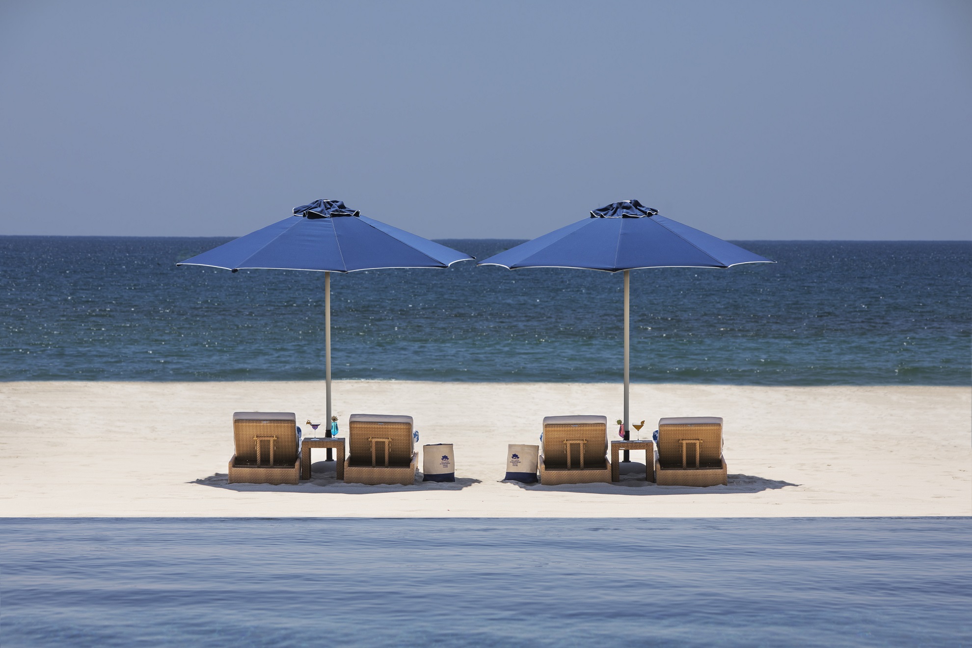 Liegen mit Sonnenschirm am Strand.